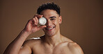 Skincare, face cream and portrait of man in studio for natural, beauty or facial routine with hydration. Happy, moisturizer and person with sunscreen for dermatology treatment by brown background.