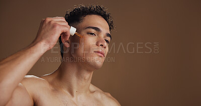 Buy stock photo Serum, skincare and man in studio, beauty and cosmetics with healthy skin on brown background. Mockup space, oil and person with shine, glow and wellness with treatment, dropper or hydration