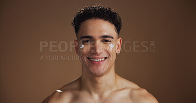 Buy stock photo Beauty, face cream and portrait of man in studio for natural, skincare or facial routine with hydration. Happy, moisturizer and person with sunscreen for dermatology treatment by brown background.