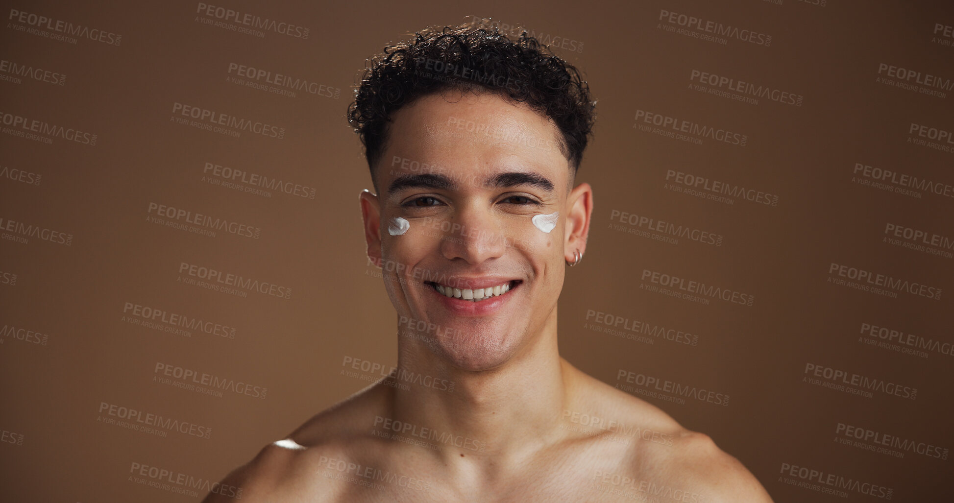 Buy stock photo Beauty, face cream and portrait of man in studio for natural, skincare or facial routine with hydration. Happy, moisturizer and person with sunscreen for dermatology treatment by brown background.