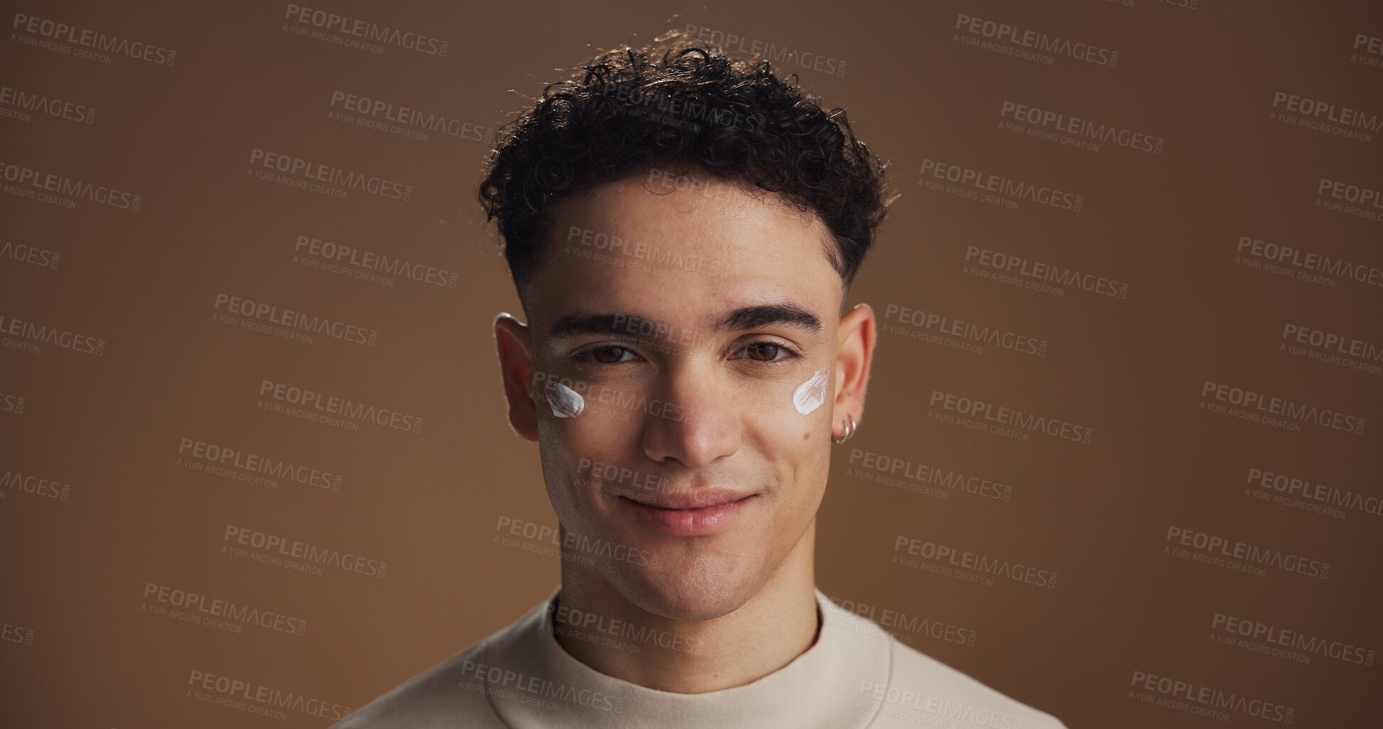 Buy stock photo Natural, face cream and portrait of man in studio for skincare, beauty or facial routine with hydration. Happy, moisturizer and person with sunscreen for dermatology treatment by brown background.
