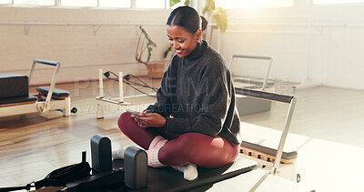 Buy stock photo Woman, phone and chat at pilates studio with smile for exercise update, social media break and texting. Female person relax on reformer, fitness and mobile app for health progress or blog at club
