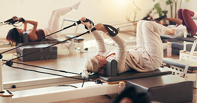 Buy stock photo Pilates, group and mature woman in class with machine for exercise, workout and improve posture. Fitness club, trainer and people with resistance equipment for wellness, health and core strength