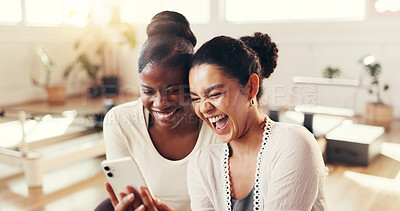 Buy stock photo Women, friends and phone with laugh at pilates studio, break and happy with funny story, fitness and meme. Girl, video and smartphone with mobile app for gossip, joke or social media at wellness club