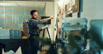 Buy stock photo Detective, man and board with evidence or case with tablet, investigation and criminal lead at police station. Investigator, problem solving and point at mindmap with tech, suspect and crime at night