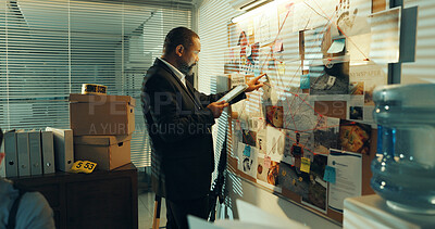 Buy stock photo Man, detective and tablet at board for investigation, pointing at evidence or documents with link for criminal case. Mature African policeman, tech and problem solving with crime analysis at night