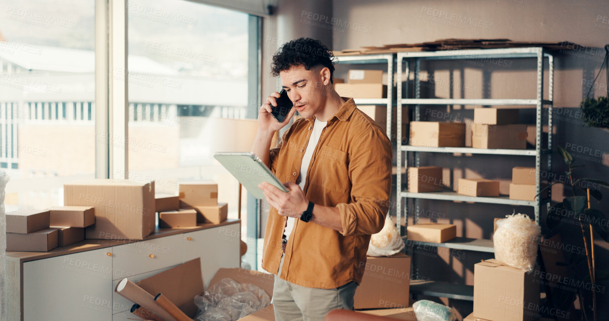 Buy stock photo Tablet, phone call and man in office with boxes for online order, ecommerce or communication. Digital technology, cellphone and male entrepreneur on mobile discussion with packages for delivery.