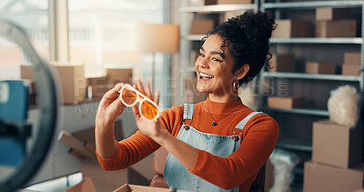 Buy stock photo Phone recording, sunglasses and supply chain with woman in studio for advertising or product review. Boxes, logistics and ring light with employee in workshop for delivery, ecommerce or shipping
