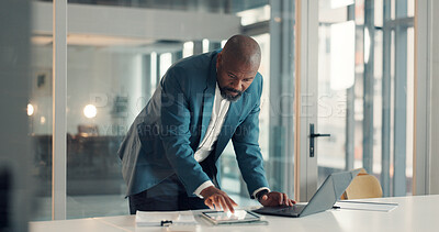 Buy stock photo Business, black man and reading on tablet in office for accounting, finance report and review budget. Mature person, laptop and typing for financial comparison, proposal information and audit payment
