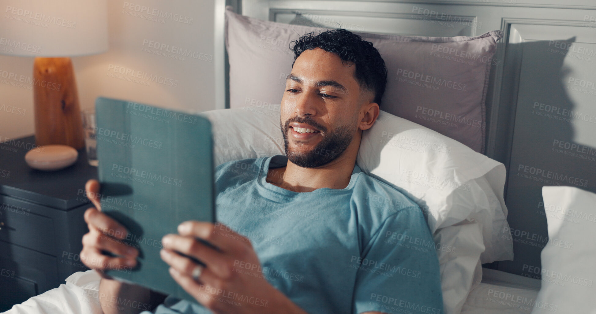 Buy stock photo Happy, man and watching movie with tablet, bedroom and subscription for entertainment, app and home. Online, film and binging series on break, streaming or person with tech, relax and smile in house