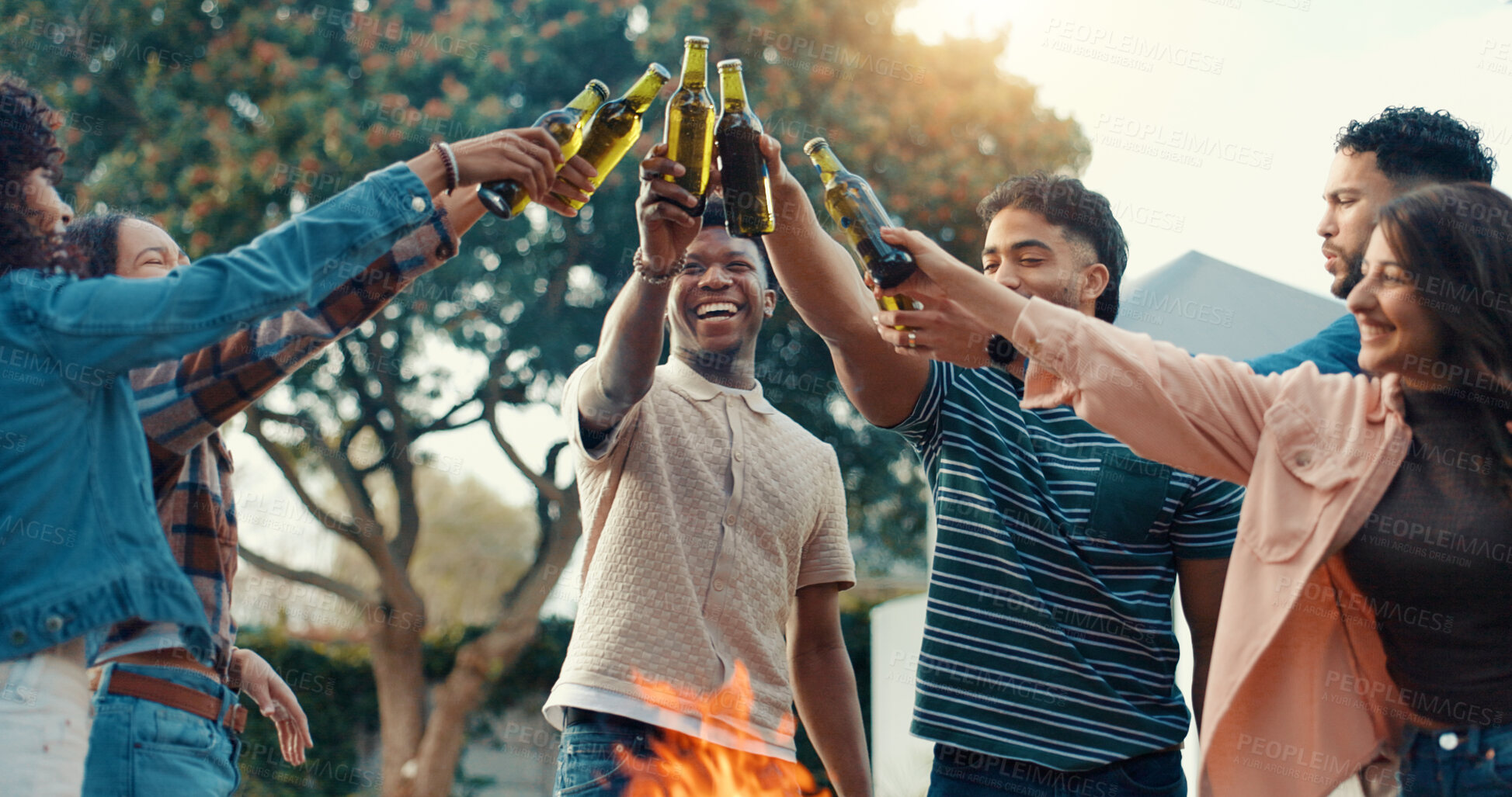 Buy stock photo BBQ, friends and toast beer outdoor for reunion celebration, social gathering or bonding at party. Happy, group of people and cheers drinks at fire for backyard event, weekend fun or hangout together