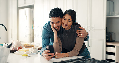 Buy stock photo Happy couple, hug and phone in kitchen for social media, picture memories and love post on app. Man, laugh and woman in home with mobile, meme and update relationship status in online marriage blog