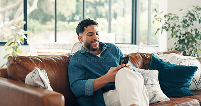 Buy stock photo Happy man, relax and chatting with phone on sofa for social media or network connection in home. Male person, user and smile with mobile smartphone for online service, message or texting app in house