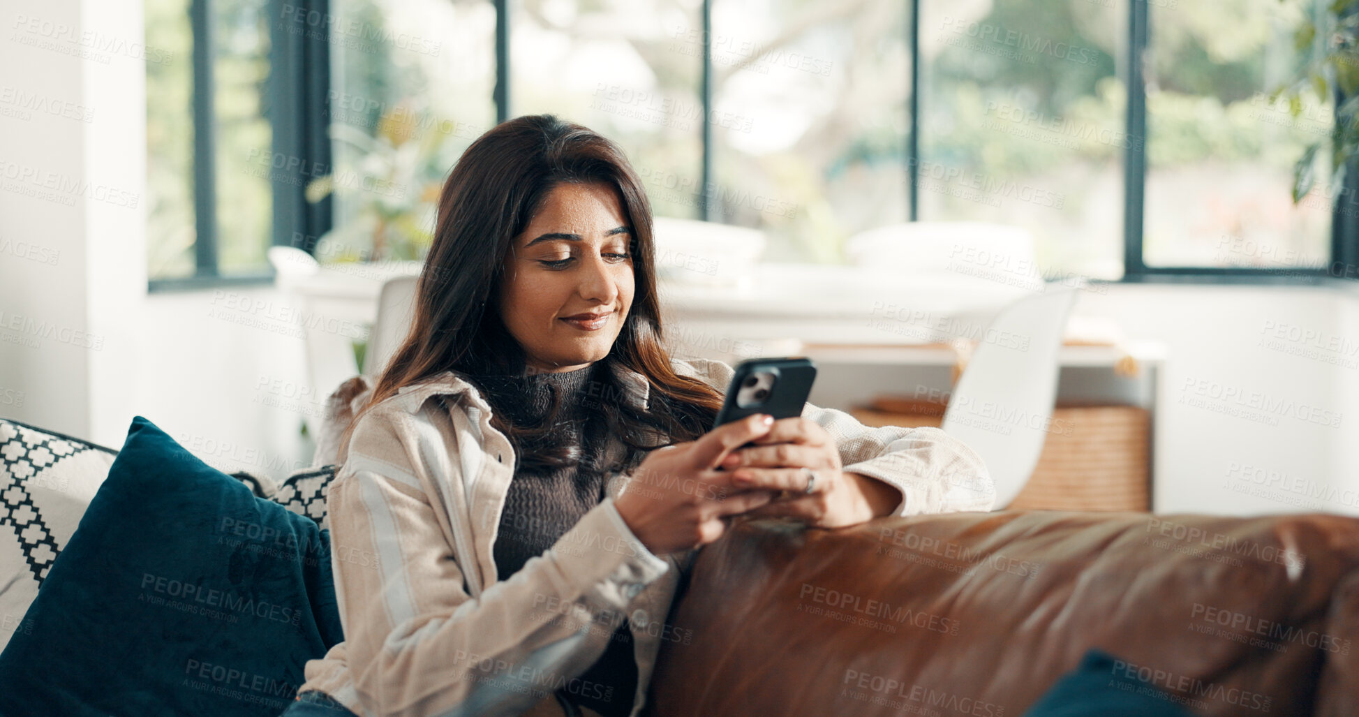 Buy stock photo Woman, relax and reading with phone for sofa, scroll social media and notification in home. Cellphone, connection and search website for download, digital app or mobile ebook and smile in living room