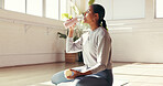 Woman, break or drinking with water in studio for hydration, recovery or natural sustainability. Female person, yogi or thirst with mineral liquid or bottle for fitness workout or rest in health club