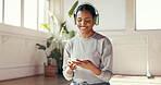 Yoga, phone and happy woman with headphones for music for workout playlist, exercise or social media. Morning, studio and person listen to audio, radio and online for wellness, health app and pilates