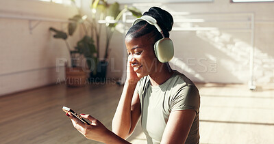 Buy stock photo Yoga, phone and black woman with headphones for music for workout playlist, exercise or social media. Morning, happy and person listen to audio, radio and online for wellness, health app and pilates