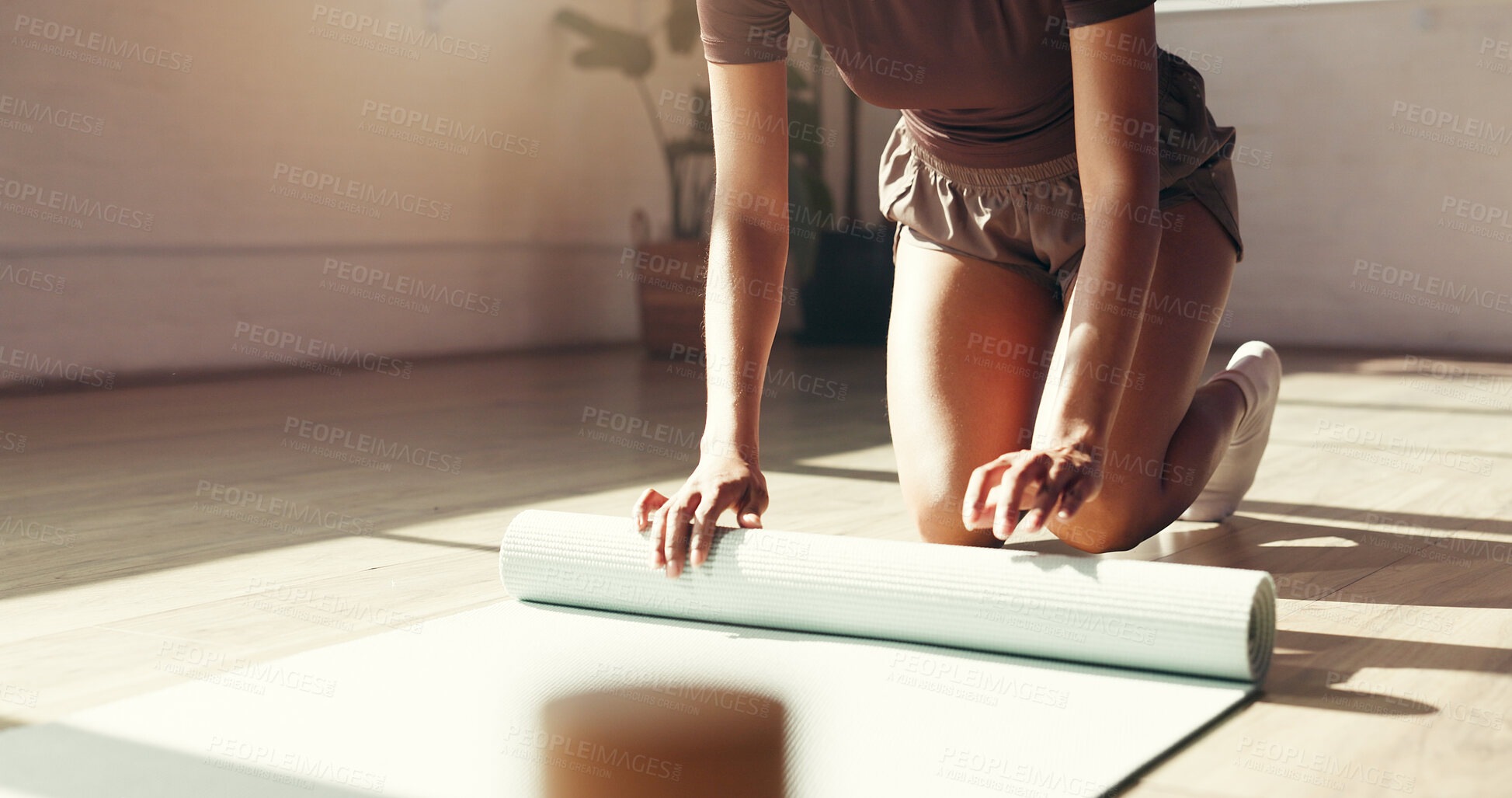 Buy stock photo Yoga, roll and hands of woman on floor to finish exercise, holistic workout and practice for balance. Morning routine, pilates studio and person packing mat for health, wellness or done with activity