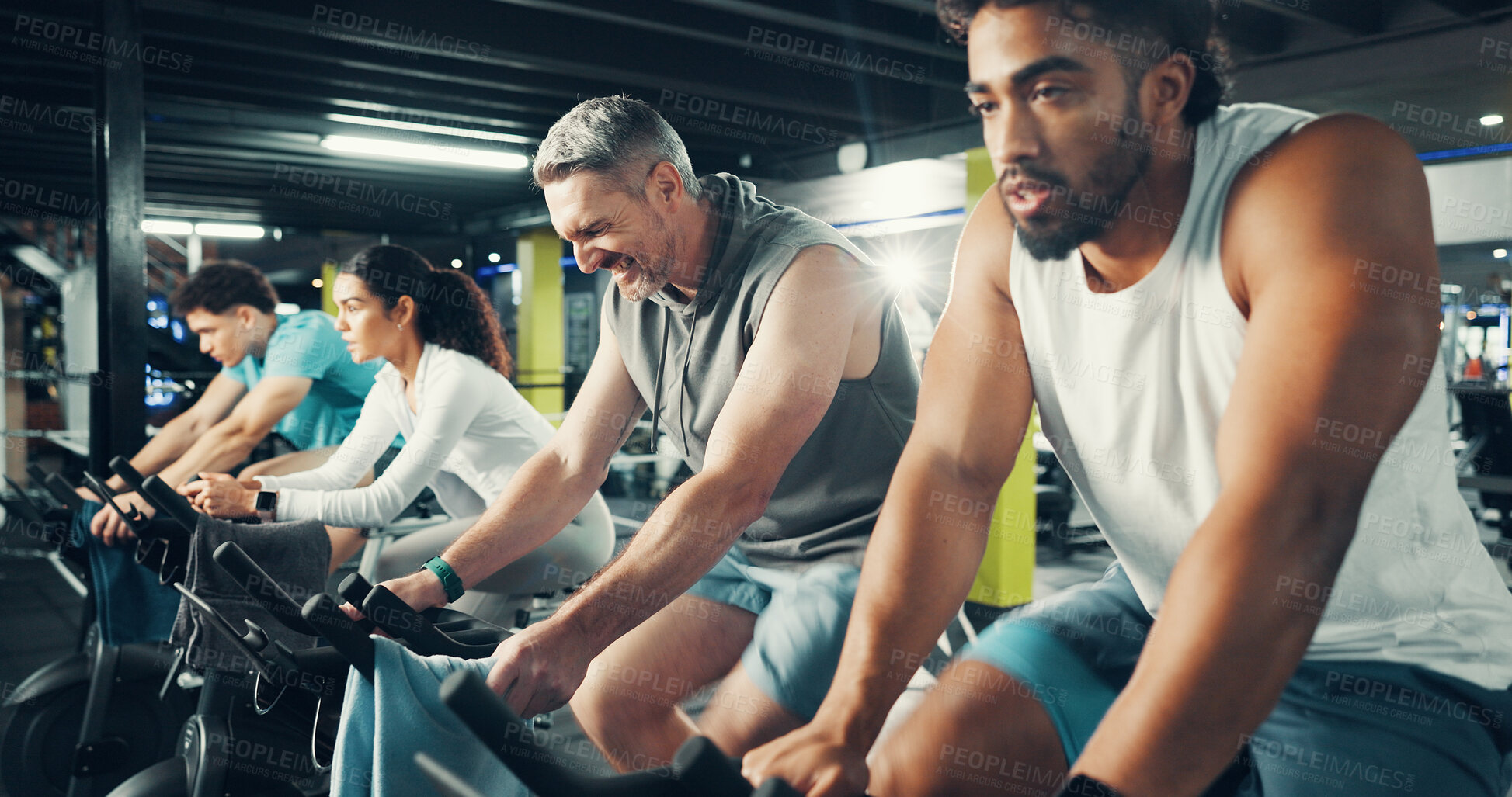 Buy stock photo Exercise bike, people and group in gym for fitness, intense challenge or workout for health. Cycling, man and training in sport club with stationary bicycle for spin class, cardio wellness or flare