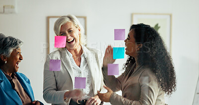 Buy stock photo Glass wall, laugh and business women planning with team for financial schedule, agenda or joke. Group, sticky note and discussion for strategy, investment ideas and funny story in office meeting