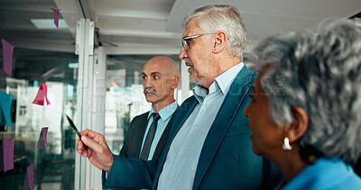 Buy stock photo Glass wall, brainstorming and business people planning with team in office for financial schedule. Mature group, sticky note and discussion for strategy, investment ideas and agenda in meeting