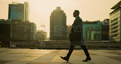 Buy stock photo Walking, employee and man in city, sunrise and commuting to work, urban planner or commuter on road. Morning, travel and mature person with ambition for career growth, journey and job opportunity