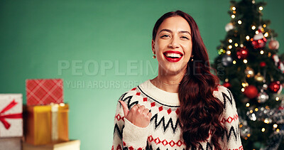 Buy stock photo Christmas, happy and portrait of woman in studio with tradition, celebration or festive holiday. Smile, pointing and person from Colombia with excitement by xmas tree and offer on green background.