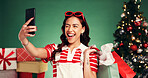 Winking, woman and shopping for Christmas, selfie and memory of festive celebration and photography. Studio, person and social media post of Xmas gifts, green background or profile picture on holiday
