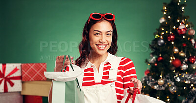 Buy stock photo Portrait, Christmas and woman with shopping bag, studio or happy with presents for December holiday. Excited, person and gifts for festive season, green background and smile for discount on Xmas