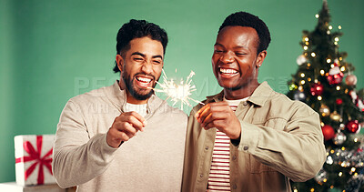 Buy stock photo Christmas, laugh and friends with sparkler in studio for festive season on green background. Happy men, xmas and firework for holiday celebration, funny and excited for party with present together