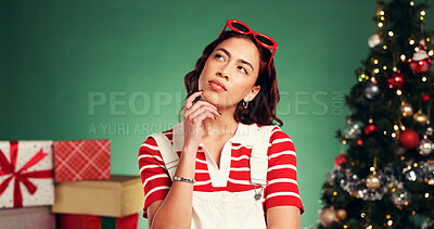 Buy stock photo Thinking, christmas and woman in studio with ideas for tradition, celebration or holiday with solution. Planning, decision and person by xmas tree for choice at festive event by green background.