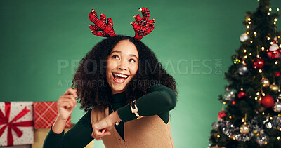 Buy stock photo Excited, woman and dancing in studio for Christmas holiday, xmas party and celebration. Smile, African person and antler for decoration, moving rhythm and energy of festive season on green background