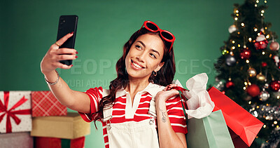 Buy stock photo Selfie, woman and shopping for Christmas, studio or memory of festive celebration or profile picture. Happy, person and photography of Xmas gifts, green background and social media post on holiday