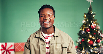 Buy stock photo Studio, laughing and portrait of man, Christmas or festive celebration with decorations or presents. Excited, black person and green background for Xmas, December and tree with ornaments on holiday