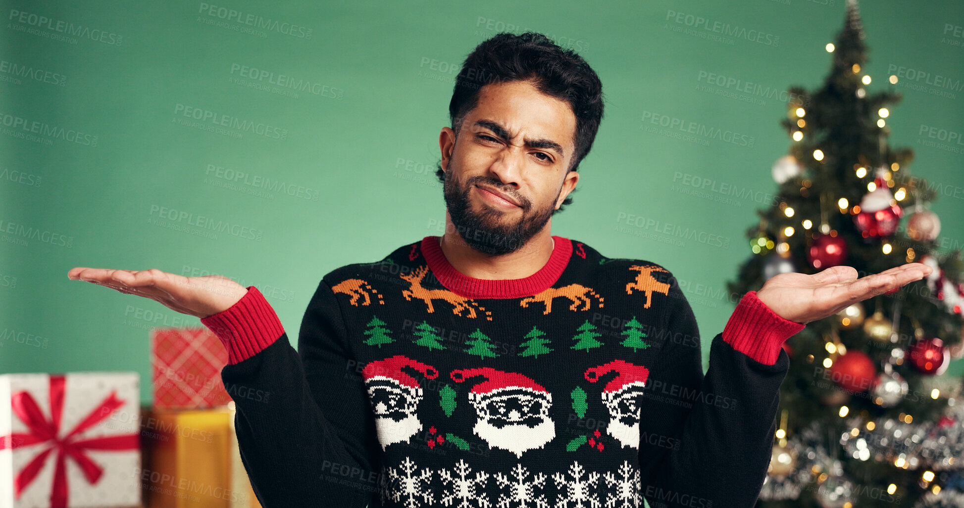 Buy stock photo Christmas, question and hands with portrait of man in studio for confused, wish list and holiday season. Dont know, festive gift idea and xmas with person on green background for why, shrug and guess