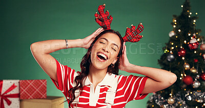 Buy stock photo Christmas, antlers and woman dance in studio for holiday celebration, excited or laugh. Xmas, funny girl and reindeer headband for festive season, party and moving with happiness on green background