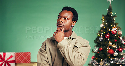 Buy stock photo Christmas, thinking and vision with black man in studio for decision, holiday season and gift planning. Festive tradition, reflection and idea with person on green background for inspiration