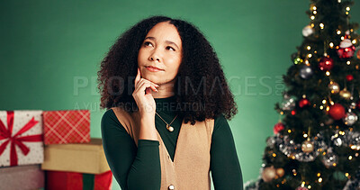 Buy stock photo Christmas, thinking and vision with woman in studio for decision, wish list or holiday season. Reflection, festive gift idea and xmas with person on green background for perspective and present