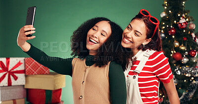 Buy stock photo Women, friends and selfie for Christmas, studio and memory of December holiday, bonding and festive. Green background, people and excited on Xmas season, happy or profile picture on social media post