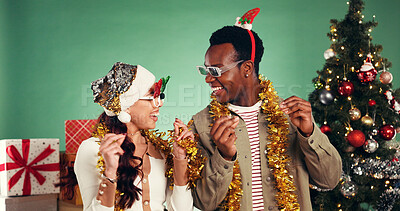 Buy stock photo Smile, people and dancing in studio for Christmas holiday, xmas party and celebration. Happy, friends and sunglasses with decorations, moving rhythm and energy for festive season on green background