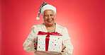 Christmas, elderly woman or gift in studio with portrait, happy or giveaway box in retirement. Senior person, excited or present on red background space for festive season, Xmas tradition or surprise