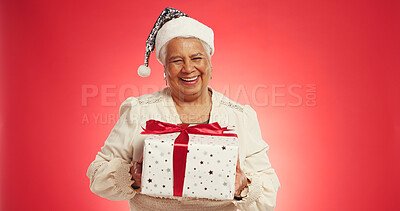 Buy stock photo Christmas, elderly woman or gift in studio with portrait, happy or giveaway box in retirement. Senior person, excited or present on red background space for festive season, Xmas tradition or surprise