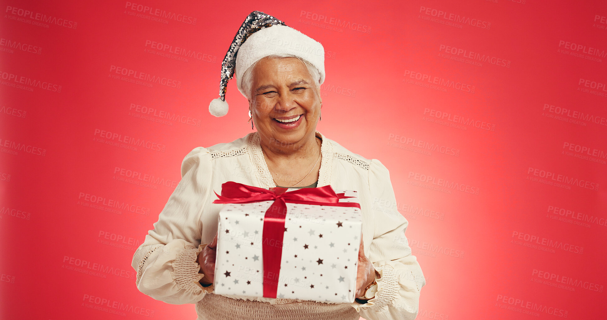 Buy stock photo Christmas, elderly woman or gift in studio with portrait, happy or giveaway box in retirement. Senior person, excited or present on red background space for festive season, Xmas tradition or surprise