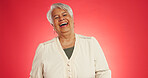 Happy, laugh and senior woman in studio with funny joke, humor reaction and positive attitude. Mockup space, retirement and mature person with comic, goofy emotion and silly on red background