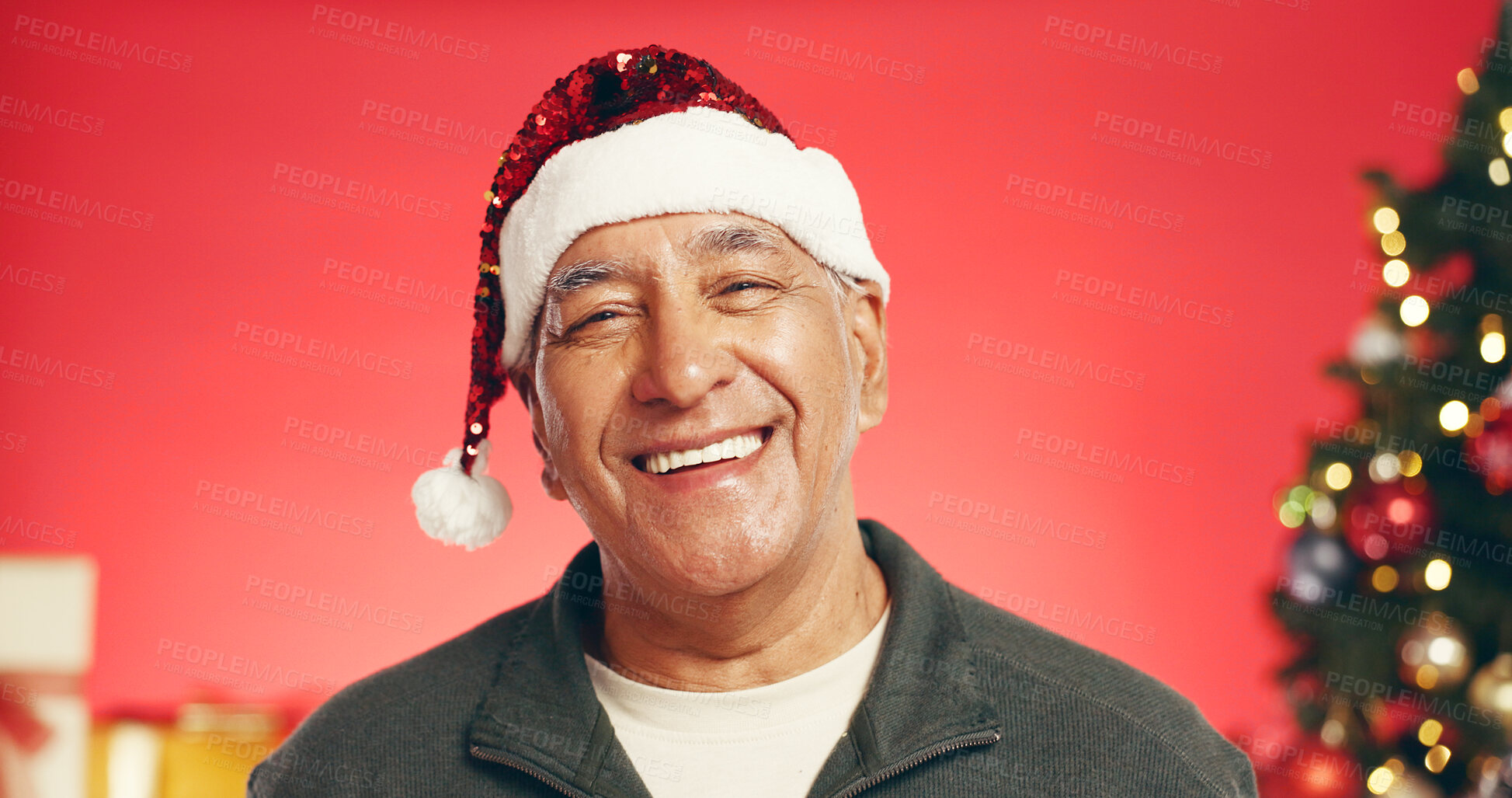 Buy stock photo Happy, christmas and portrait of senior man in studio with decorations for festive tradition. Smile, santa hat and elderly male person from Mexico with pride for xmas holiday by red background.