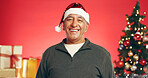 Smile, christmas and portrait of senior man in studio with decorations for festive tradition. Happy, santa hat and elderly male person from Mexico with pride for xmas holiday by red background.