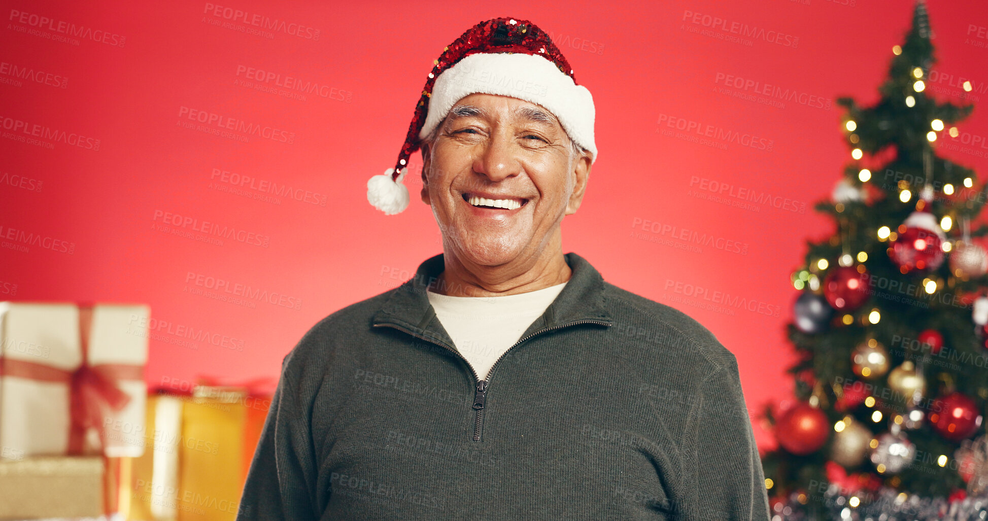 Buy stock photo Smile, christmas and portrait of senior man in studio with decorations for festive tradition. Happy, santa hat and elderly male person from Mexico with pride for xmas holiday by red background.