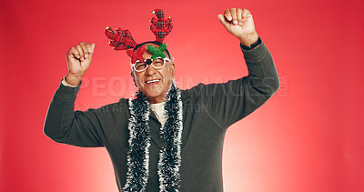 Buy stock photo Christmas, dance and portrait of senior man in studio for holiday, vacation and festive season. Space, energy and elderly person for xmas celebration, December tradition and antlers on red background