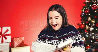 Buy stock photo Surprise, woman and present in studio for Christmas holiday, wishlist and festive celebration. Excited, female person and package for xmas gift, giveaway reward and tradition prize on red background