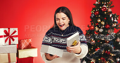 Buy stock photo Surprise, woman and gift in studio for Christmas holiday, wishlist and festive celebration. Excited, female person and package for xmas present, giveaway reward and tradition prize on red background